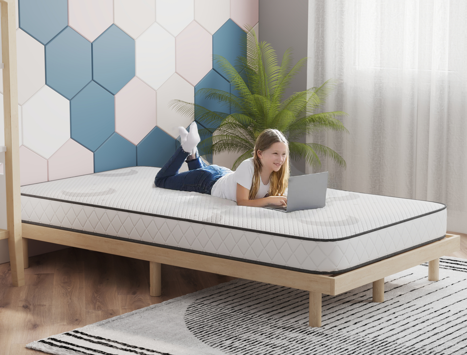 kid using a laptop on a king single mattress on a bed frame in a bedroom from Isaak